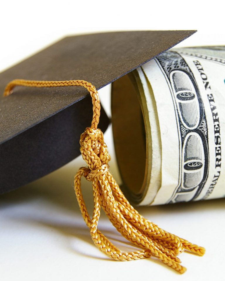 graduation cap and cash roll, closeup